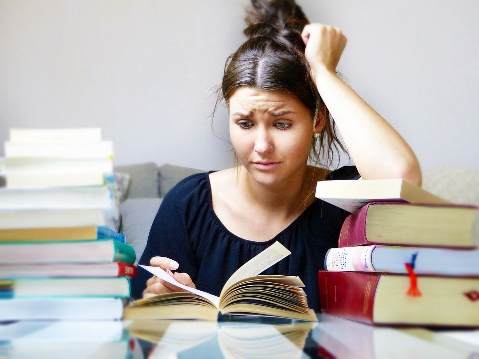 A student reading a book, looking clearly stressed. Perhaps mindfulness can help them?